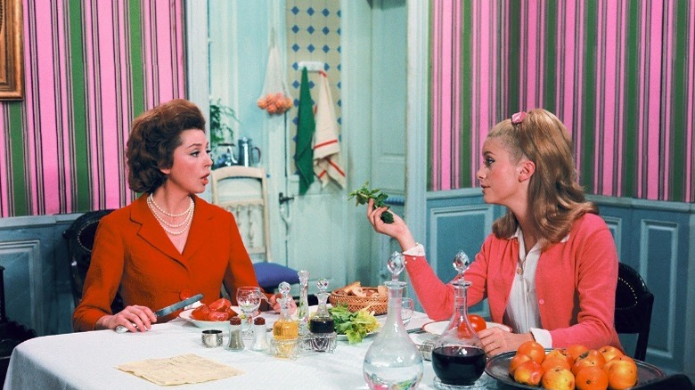 Anne Vernon and Catherine Deneuve eating dinner