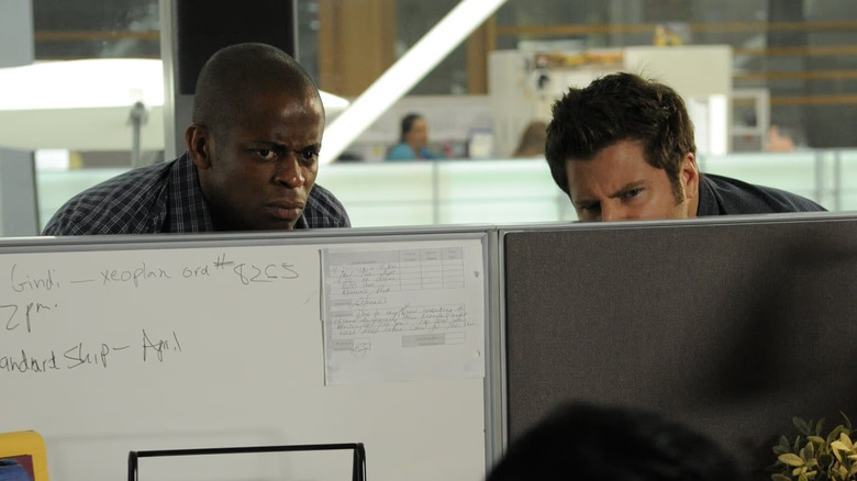 James Roday Rodriguez and Dulé Hill as Shawn and Gus hiding in a cubicle on Psych