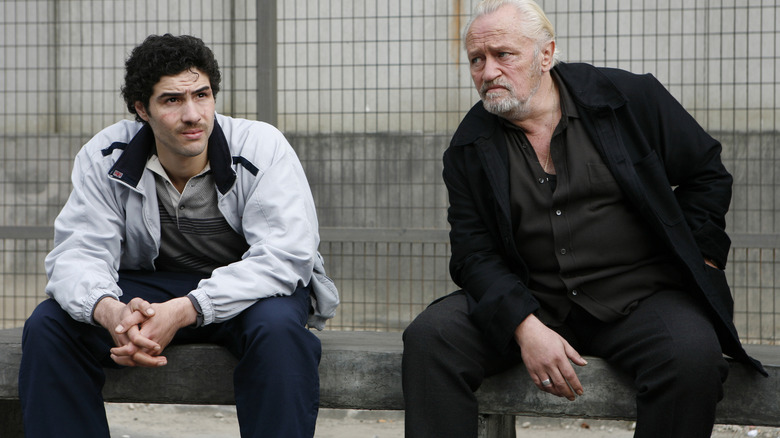 Tahar Rahim and Niels Arestrup as Malik and César sitting on a bench in A Prophet