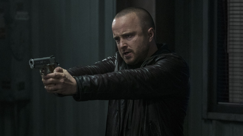 Aaron Paul as Jesse Pinkman, aiming a gun in El Camino