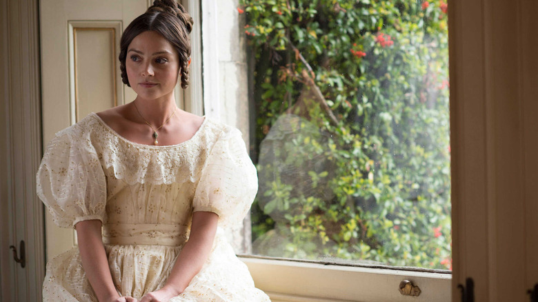 Victoria (Jenna Coleman) sits by a window on Victoria