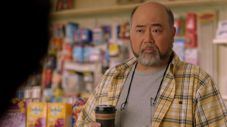 Appa (Paul Sun-Hyung Lee) holds a cup of coffee in Kim's Convenience