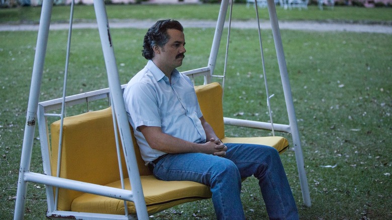 Wagner Moura as Pablo Escobar sitting on a swing in Narcos