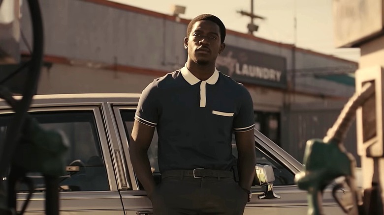 Damson Idris as Franklin Saint standing with his hands in his pockets next to a car in Snowfall