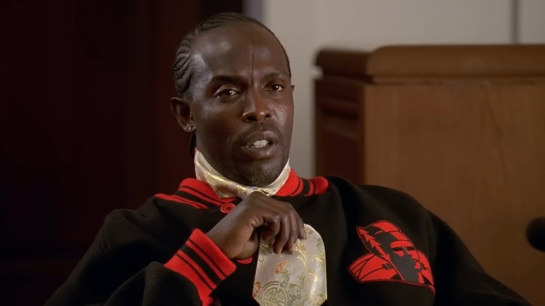 Michael K. Williams as Omar Little sitting on the stand and playing with his tie in The Wire