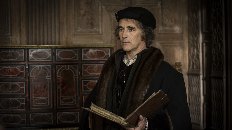 Thomas Cromwell (Mark Rylance) holding book in Wolf Hall