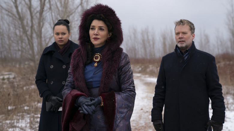 Frankie Adams as Roberta Draper and Ted Dykstra as Gareth stand behind Shohreh Aghdashloo as Chrisjen Avasarala in a snowy field on The Expanse