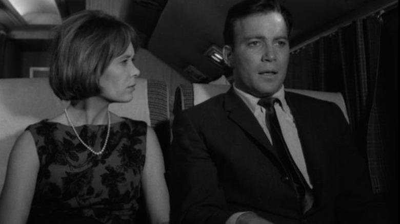 Christine White as Julia Wilson looks at her husband Bob Wilson played by William Shatner as they sit together in a plane on The Twilight Zone