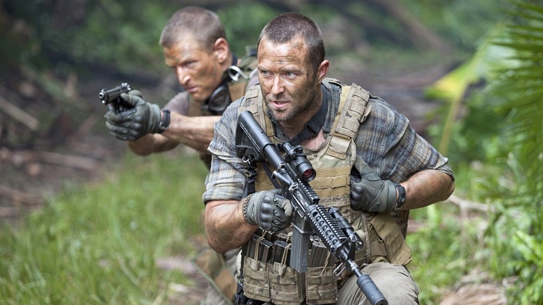 Michael Stonebridge (Philip Winchester) and Damian Scott (Sullivan Stapleton) walk through the jungle on Strike Back