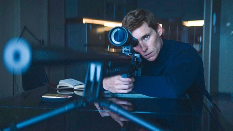 The Jackal (Eddie Redmayne) aims a sniper rifle on The Day of the Jackal