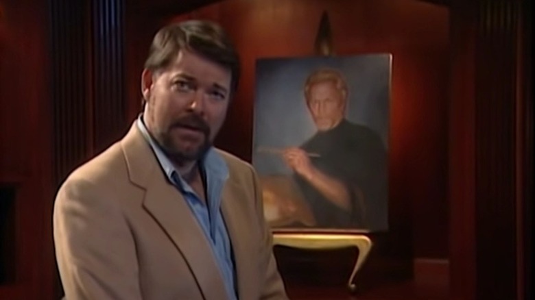 Jonathan Frakes sitting in front of a portrait on Beyond Belief