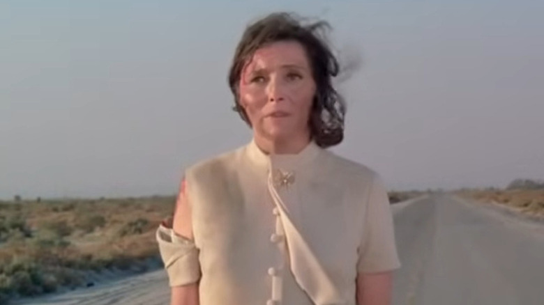 Patricia Neal as Ellen Alexander, standing disheveled and battered in the middle of a rural road in the Ghost Story episode Time of Terror