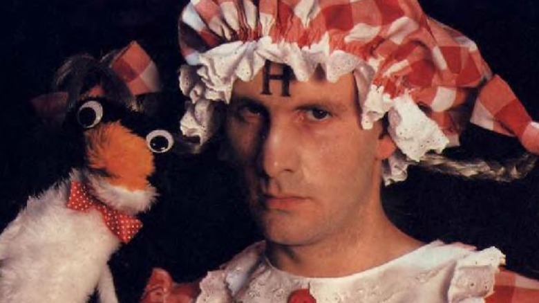 Chris Barrie as Arnold Rimmer, wearing a bonnet and holding a penguin on Red Dwarf