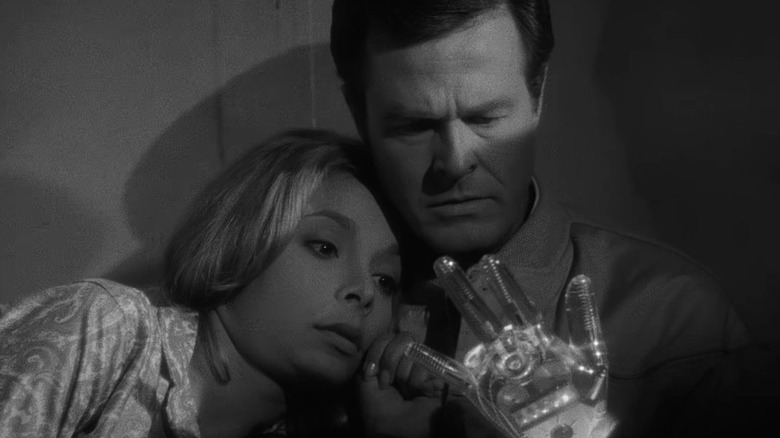 Robert Culp and Arlene Martel as Trent and Consuelo Biros, looking at his glass mechanical hand in The Outer Limits episode Demon with a Glass Hand