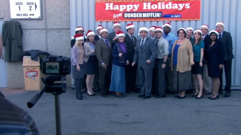 The staff of Dunder Mifflin posing for a Christmas picture on The Office