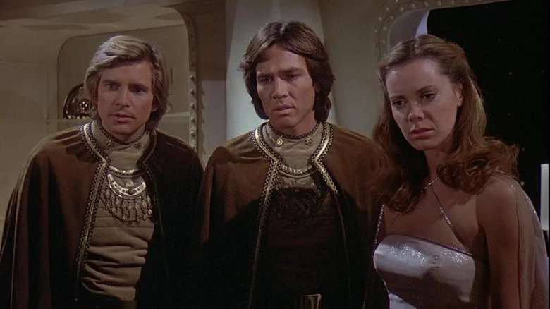 Crew in ornate clothing looking to the side on Battlestar Galactica