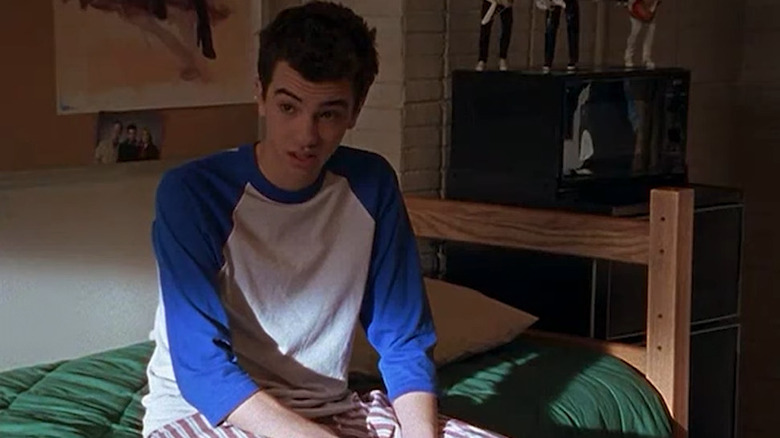 Steven Karp sitting on a bed on Undeclared