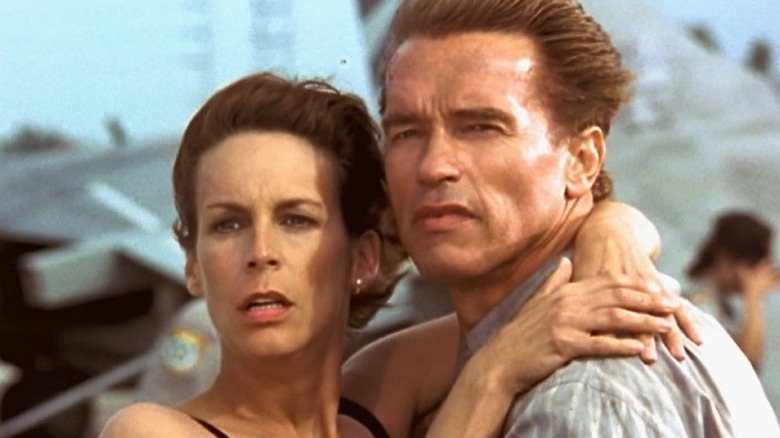 Jamie Lee Curtis and Arnold Schwarzenegger in front of a Harrier jet.