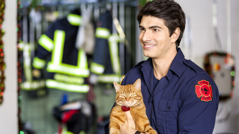 Brandon Routh as Zachary smiling holding a cat in The Nine Lives of Christmas