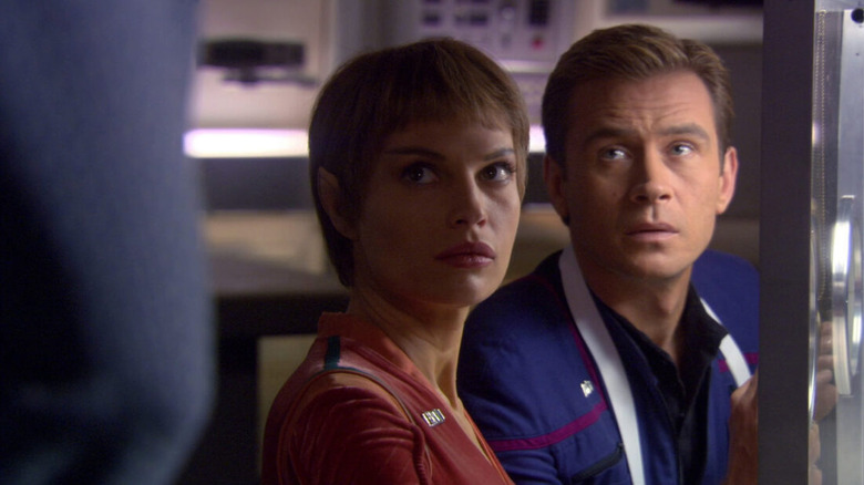 T'Pol (Jolene Blalock) and Trip Tucker (Connor Trinneer) glance up pensively in Star Trek: Enterprise