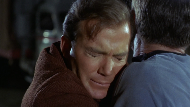 Kirk (William Shatner) grimaces while holding back McCoy (DeForest Kelley) in Star Trek: The Original Series