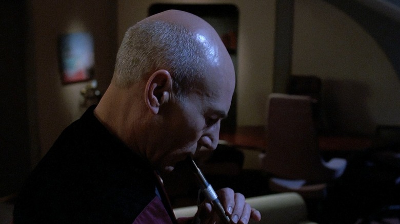 Picard (Patrick Stewart) solemnly plays a flute in Star Trek: The Next Generation