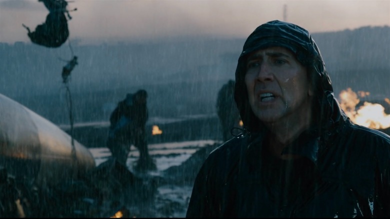 Nicolas Cage in the rain amid plane wreckage in Knowing