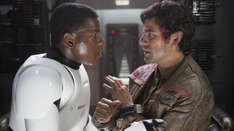 Finn in trooper armor with wounded Poe