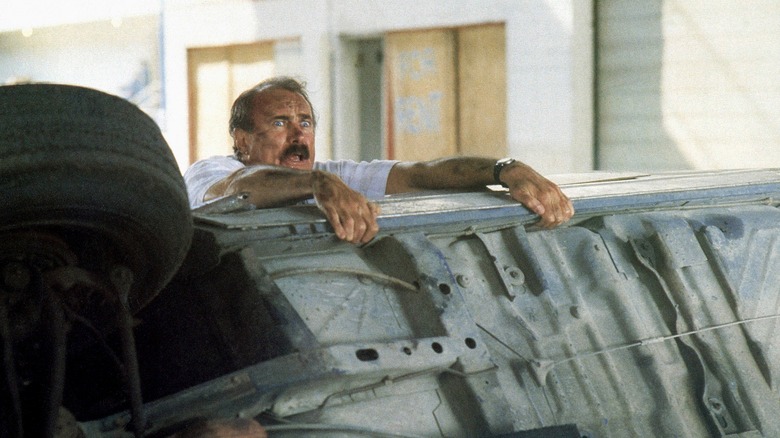 Dabney Coleman leaning on his wrecked car