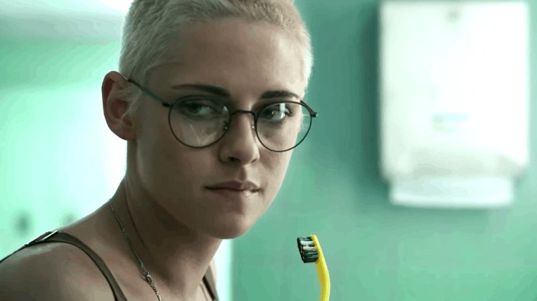 Kristen Stewart in glasses holding toothbrush