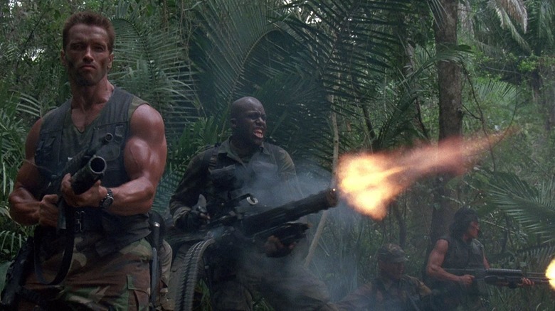 Arnold Schwarzenegger, Bill Duke, Richard Chaves, and Sonny Landham shooting into the trees