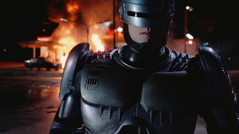 RoboCop walking away from a burning gas station