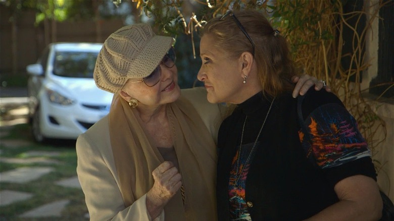 Debbie Reynolds crochet hat and Carrie Fisher staring at one another smiling