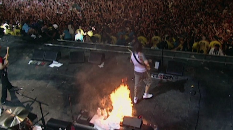 A fire onstage as a band plays to a massive crowd at Woodstock 99