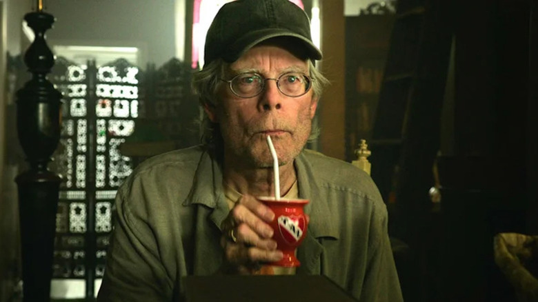 Stephen King slurps from a cup as the shopkeeper in It: Chapter Two