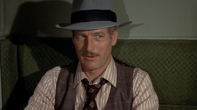 Henry Gondorff (Paul Newman) sits on a green chair in The Sting