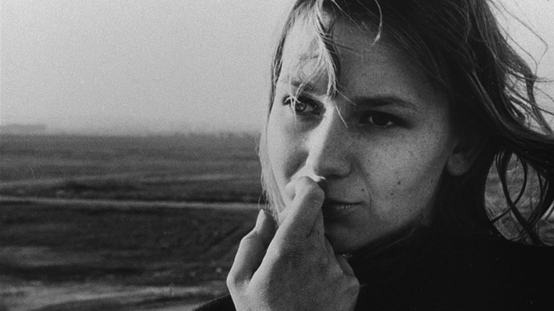 Closeup of a woman's face with her hand held to her mouth