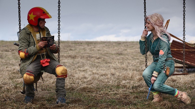 Turbo kid relaxes with a friend on some swings