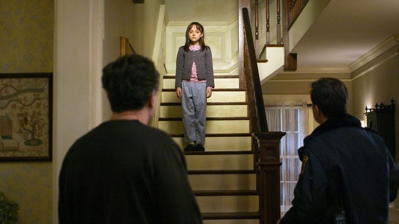 Robert De Niro's David and Dylan Baker's Sherrif Hafferty staring at Dakota Fanning's Emily on the stairs in Hide and Seek