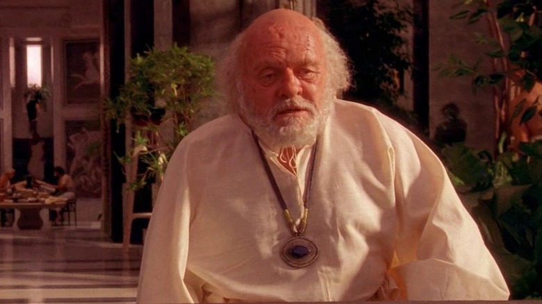 Anthony Hopkins as Ptolemy sitting at his desk in Alexander