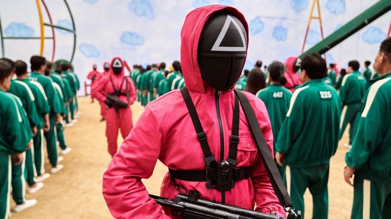 A masked guard in a pink jumpsuit in Squid Game