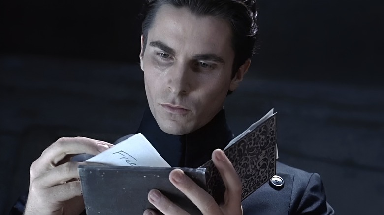 Christian Bale as John Preston looks over a booklet in Equilibrium