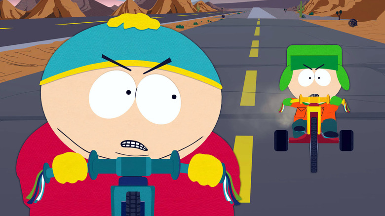 Cartman and Kyle on Big Wheels, out on the open road. Cartman is angry.