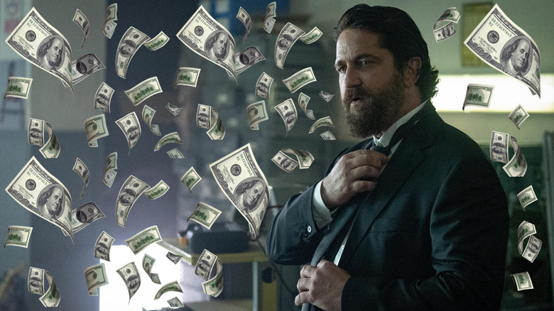 Gerard Butler as Big Nick putting on a suit surrouned by money in Den of Thieves 2: Pantera