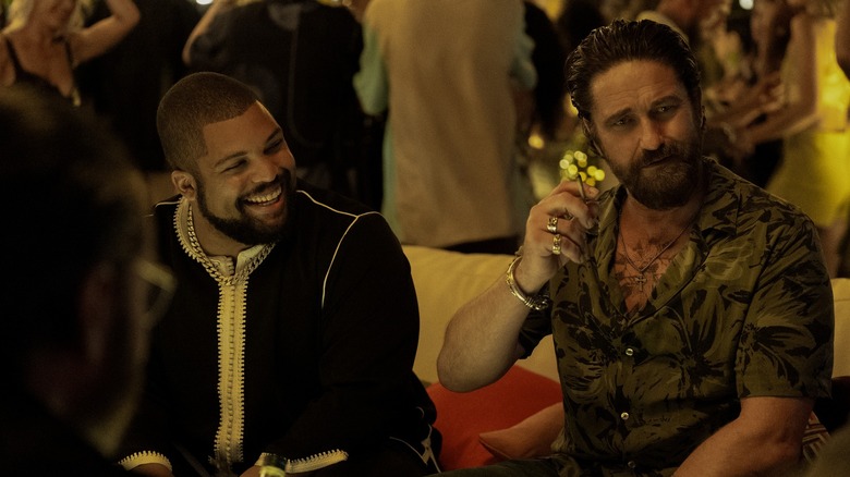 O'Shea Jackson Jr.'s Donnie and Gerard Butler's Big Nick laughing together at the club in Den of Thieves 2: Pantera