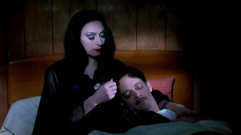 Anjelica Huston and Raul Julia relaxing in bed in The Addams Family