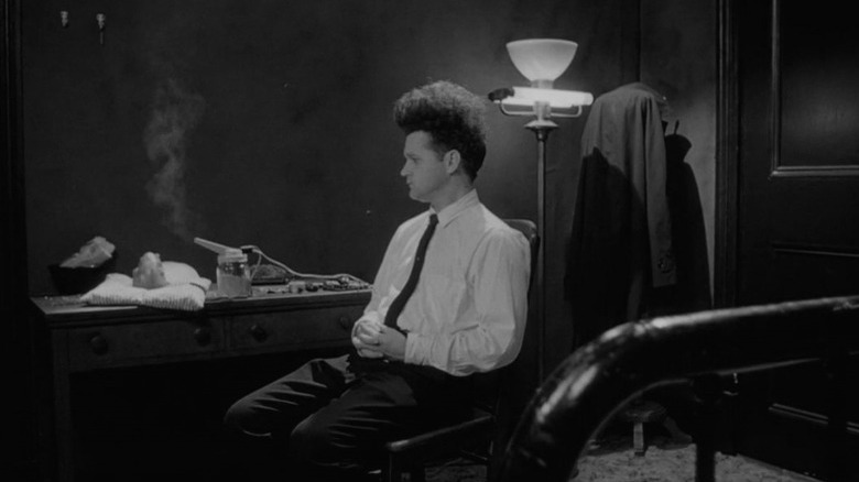 A quiet moment for the seated protagonist of Eraserhead