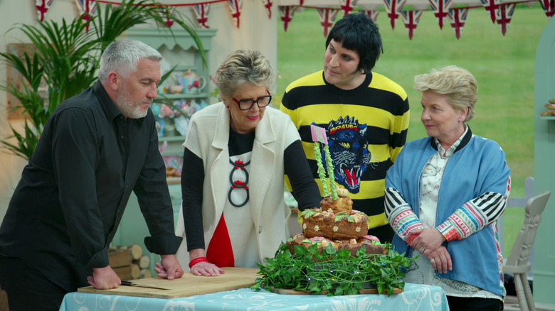 The Great British Bake-Off hosts and judges inspect a showstopper.