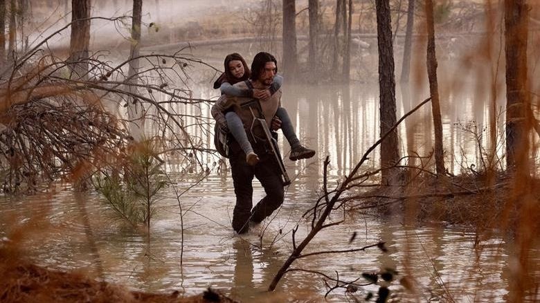 Adam Driver and Ariana Greenblatt walking through a swamp in 65