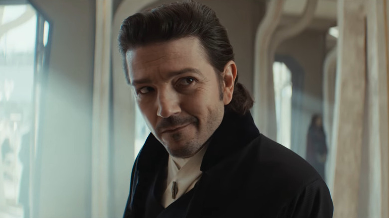 Cassian Andor smiling and wearing a wealthy disguise